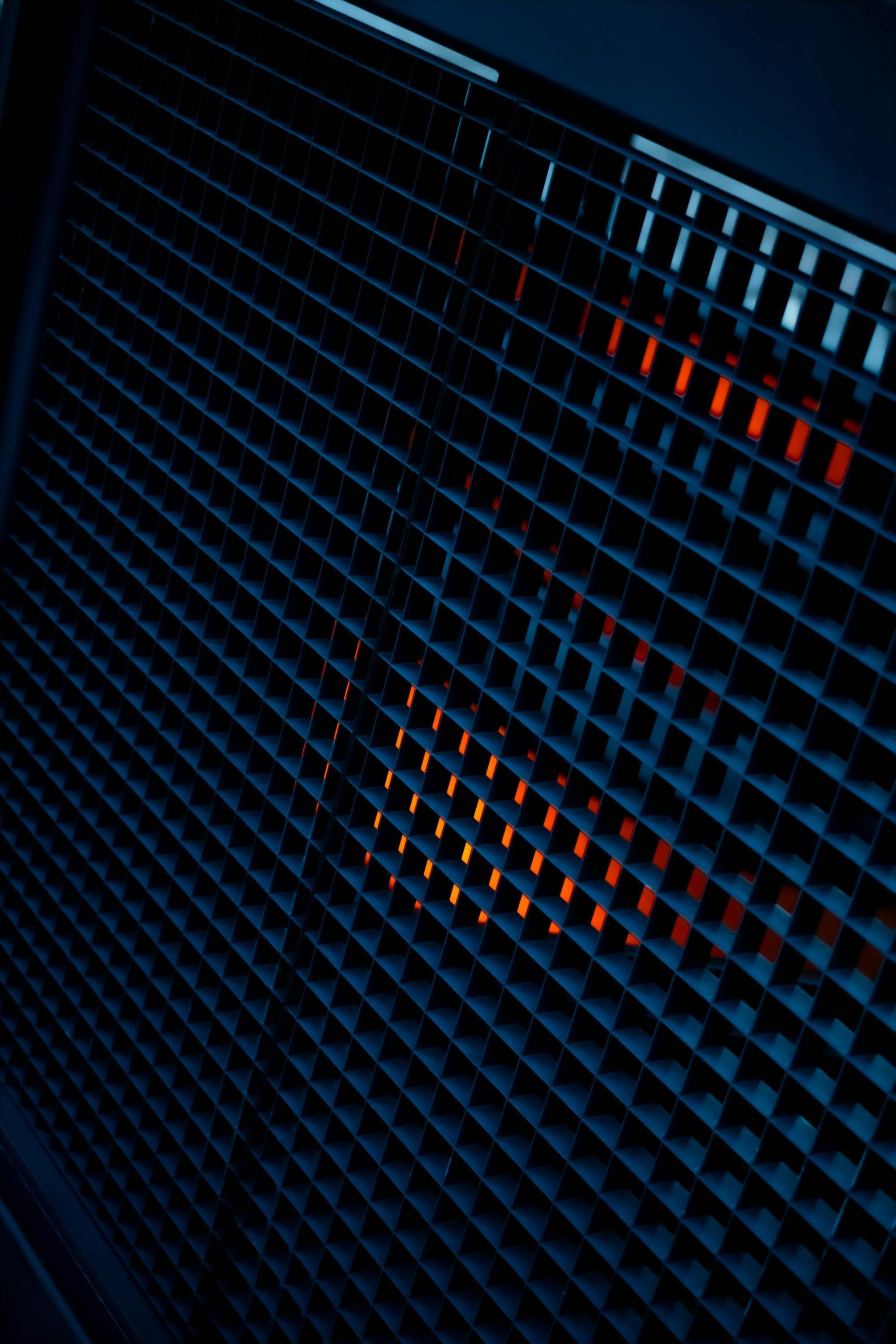A dark architectural grid illuminated with blue and orange light.