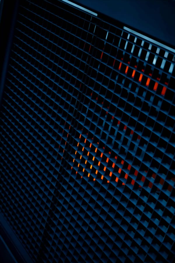 A dark architectural grid illuminated with blue and orange light.
