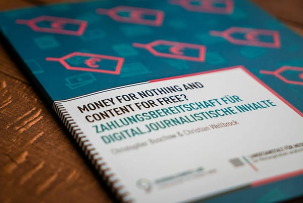 A publication about paid digital journalism on a wooden table.